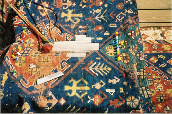 Detailed hand reweaving in progress on an Oriental rug